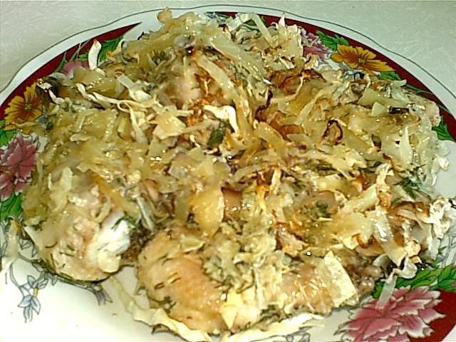 Cabbage baked on a baking sheet with pieces of chicken fillet