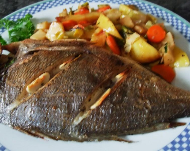 Dorada baked with potatoes and vegetables