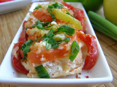 Pink salmon with tomatoes and onions in foil in the oven