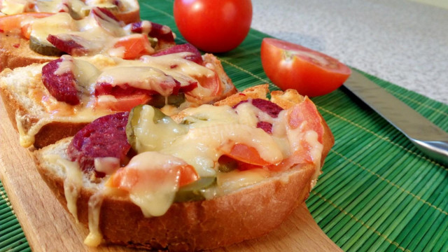 The simplest pizza on a loaf with tomatoes and salami