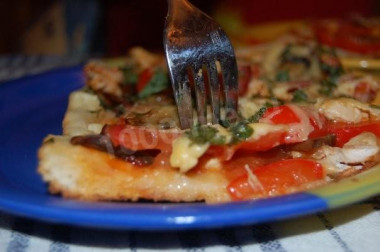 Italian thin pizza with ham, cheese and mushrooms