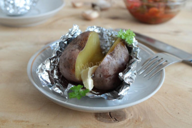 Baked potatoes in a slow cooker in foil in a uniform