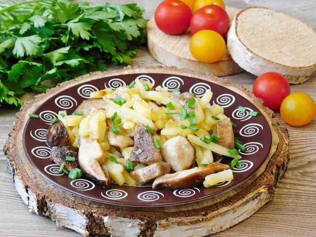 Potatoes with white fried mushrooms in a frying pan