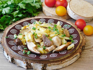 Potatoes with white fried mushrooms in a frying pan