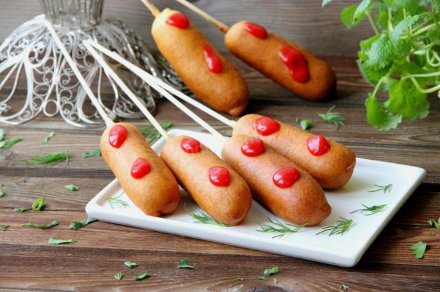 Sausages in liquid corn dough on a stick fried in oil