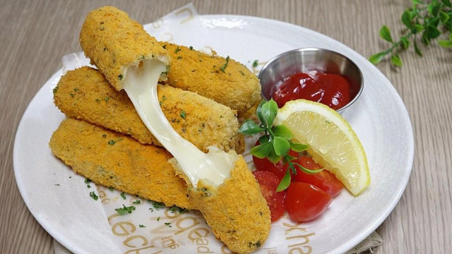 Snack sticks with cheese in milk breading with parsley