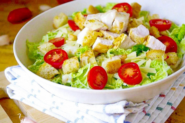 Caesar salad with cheese, tomatoes, chicken and crackers