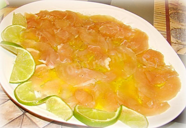 Chicken carpaccio meat plate with lemon and lime