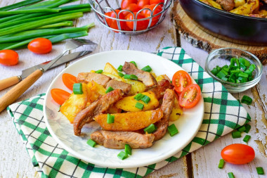 Fried potatoes with meat on frying pan