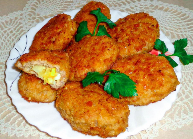 Meat dishes with egg and onion in a frying pan