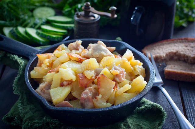 Fried potatoes with chicken in a frying pan