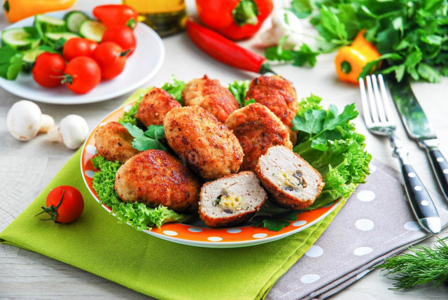 Chicken cutlets with mushrooms and cheese on frying pan