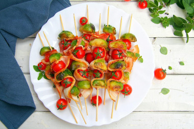 Skewers of Brussels sprouts with bacon in a frying pan