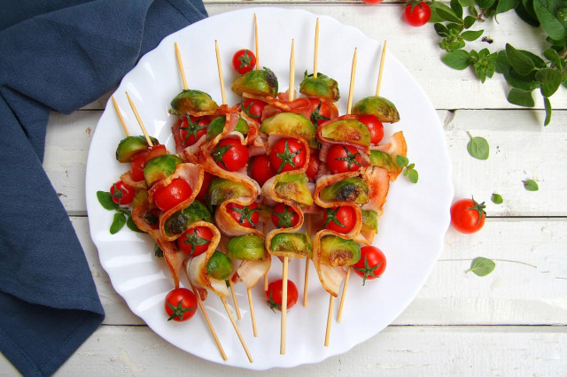 Skewers of Brussels sprouts with bacon in a frying pan