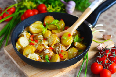 Fried potatoes with cheese in a frying pan