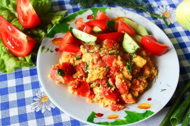 Fried eggs with tomatoes in a pan