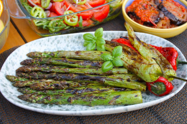 Green asparagus on charcoal on the grill