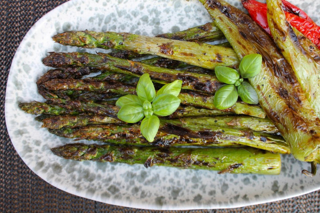 Green asparagus on charcoal on the grill