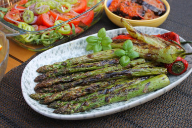 Green asparagus on charcoal on the grill