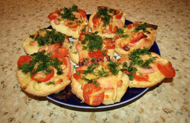 Mini pizzas with boiled sausage and cherry tomatoes