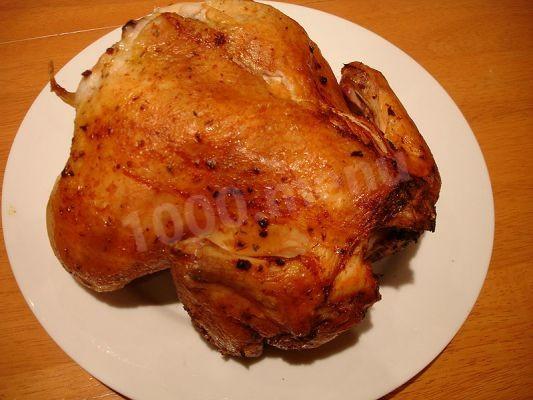 Whole chicken in mayonnaise in foil on coals