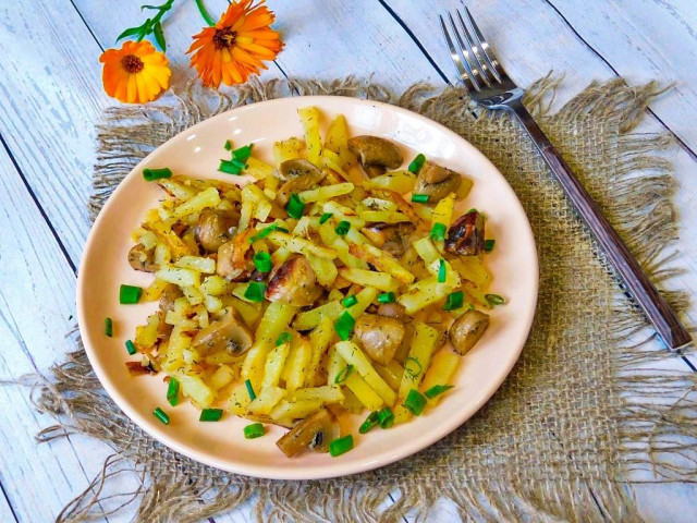 Fried potatoes with mushrooms in a frying pan