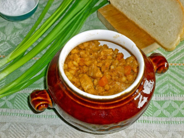 Porridge with meat in a pot in the oven pearl barley