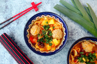 Asian soup with meatballs noodles and beans