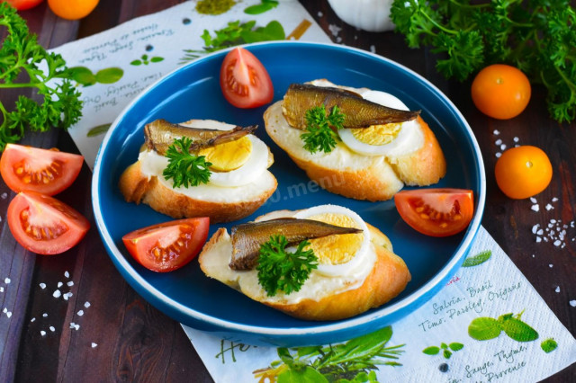Sandwiches with sprats, melted cheese and egg
