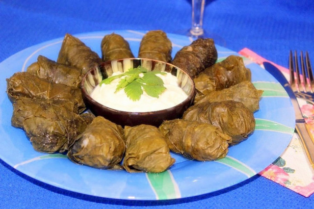 Minced meat dolma with mint in grape leaves in matsoni sauce