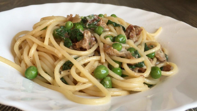 Spaghetti with bacon, green peas and hard cheese