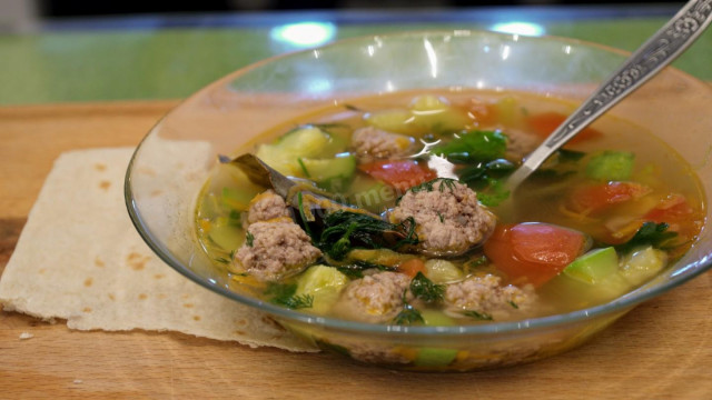 Summer soup with meatballs, vegetables and herbs