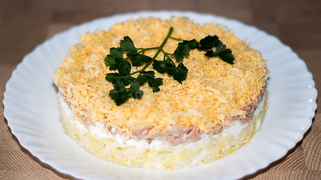 Layered salad with cod liver, hard cheese and potatoes