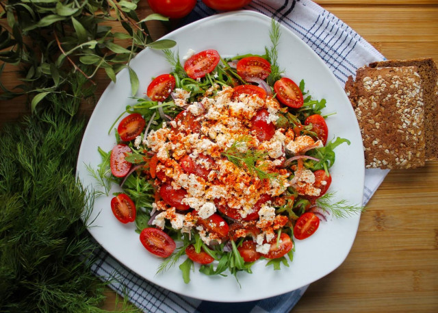 Simple salad of cherry tomatoes and cheese rucolla