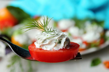 Appetizer of red and yellow tomatoes with cheese and garlic