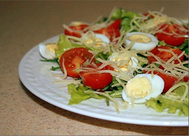 Salad with arugula and tomatoes and quail eggs