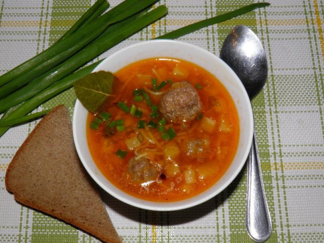 Chicken broth soup with tomato toasting and meatballs