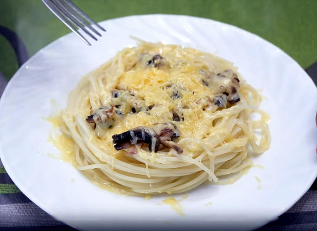 Spaghetti pasta with champignons and hard parmesan cheese
