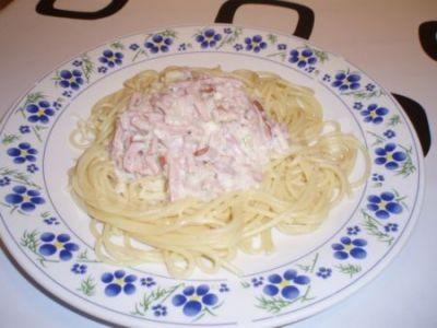 Pasta in cream sauce with ham and hard cheese