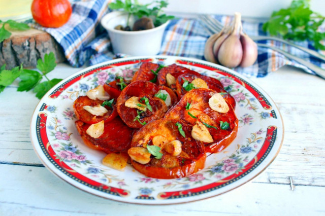 Fried tomatoes in a pan with garlic