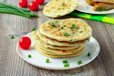 Tortillas with green onions in a pan
