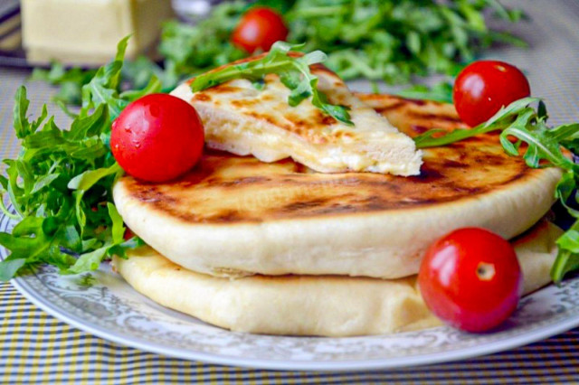 Khachapuri with cottage cheese and cheese in a frying pan