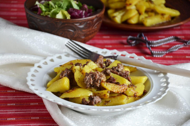 Fried potatoes with stewed meat in a frying pan