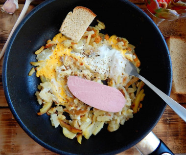 Fried potatoes with egg in a frying pan
