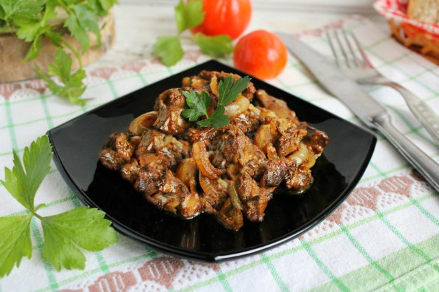 Fried chicken liver in flour with onions in a frying pan