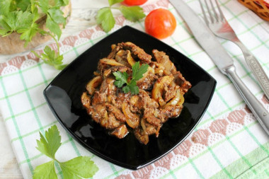 Fried chicken liver in flour with onions in a frying pan