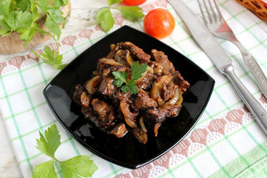 Fried chicken liver in flour with onions in a frying pan