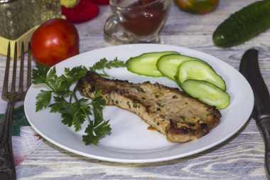 Roast pork loin on a bone in a frying pan