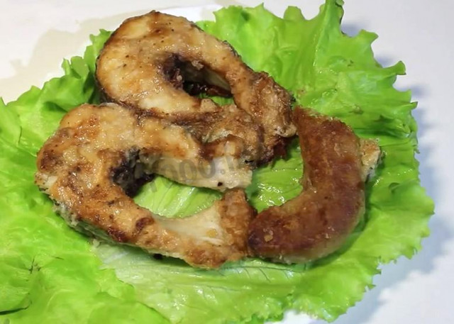Pike fried in flour in a frying pan