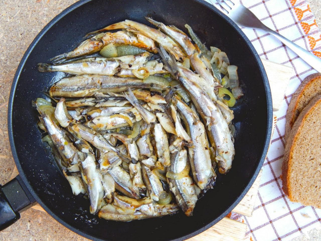 Capelin fried in a pan with onions
